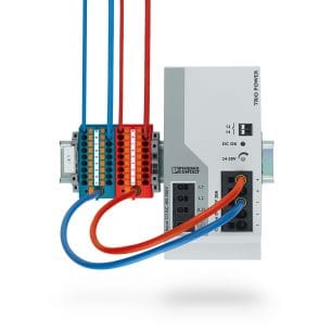 A blue and red power supply distribution block from Phoenix Contact mounted on a DIN rail.