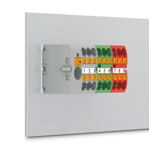Several grey, green, and red Phoenix Contact distribution blocks mounted directly on a surface.